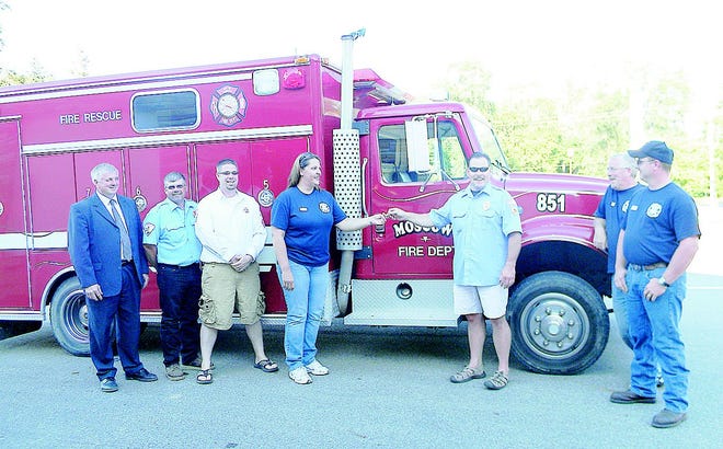 Camden Fire Lt. Scott Hodshire hands over the truck key to Moscow Fire Chief Patti Smith. From left, Camden Village President Harold Walker, Camden Fire Lt. Emery Hartman, Camden Fire Chief Mike Kurtz, Moscow Fire Chief Patti Smith, Camden Fire Lt. Scott Hodshire, Moscow Fire Capt. Timothy Nickels and Moscow Asst. Chief John Smith.