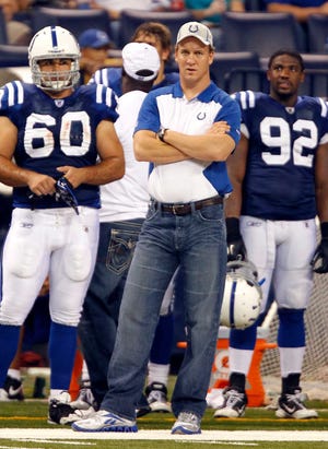 Indianapolis Colts quarterback Peyton Manning, center, looks on next to teammates John Gill (60) and Jerry Hughes during the fourth quarter of an NFL preseason football game against the Washington Redskins in Indianapolis, on Friday, Aug. 19, 2011. (AP Photo/Michael Conroy)