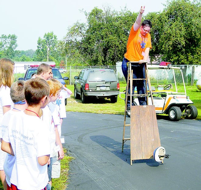 Camp Counselor Stephanie Cobb drops a brain, made from Jello, in a helmet off a ladder to demonstrate the importance of wearing a helmet.