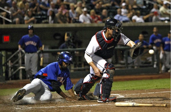 Fernando Perez of the Bisons scores as Clippers catcher Luke Carlin waits on the ball.