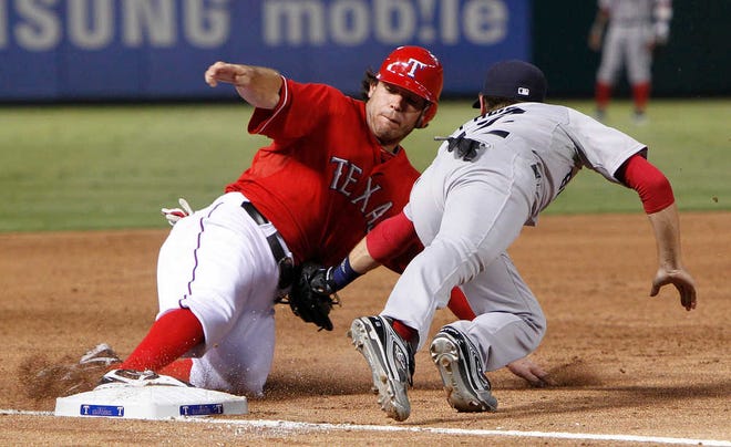 Texas' Ian Kinsler beats the tag from Boston Red Sox third baseman Jed Lowrie during their game Monday in Arlington. The Rangers won, 4-0.