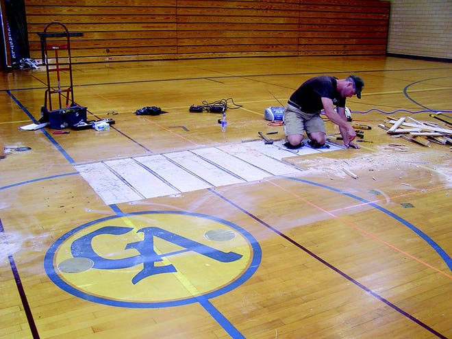 Shawn Frick began tearing up damaged sections of the high school gym floor on Monday, and expects to work two weeks on repairs.