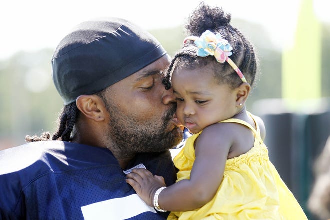 New England Patriots linebacker Jerod Mayo kisses his daughter Chya after NFL football training camp practice in Foxborough, Mass. Saturday, July 30, 2011. (AP Photo/Winslow Townson)
