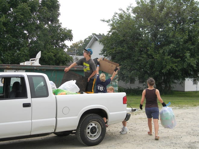 Members of the Hillsdale County 4-H Youth Conservation Council help dispose of trash brought by a community member for the Allen Township Cleanup Day.