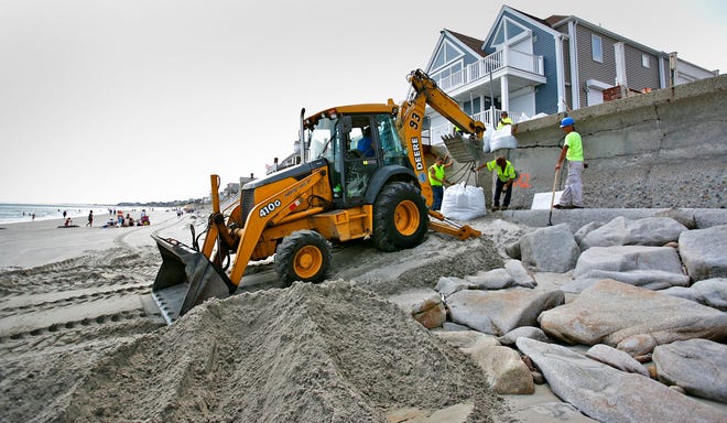 A team from the Marshfield DPW Highway Division work to shore up a section of seawall on Bay Avenue in the Green Harbor section of town. The section near numbers 50 and 56 was damages last January during a blizzard. They were working Thursday afternoon August 25, 2011.