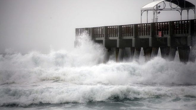 The William O. Lockhart Municipal Pier in Lake Worth is pummeled by waves Thursday afternoon. A tropical storm warning was in place from Jupiter Inlet south to Deerfield Beach for coastal waters starting 20 miles out and out to Bahamian waters. (Bruce R. Bennett/The Palm Beach Post)