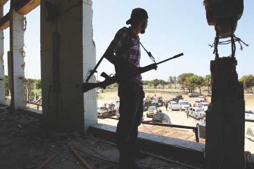 A Libyan rebel fighter stands in the destroyed building of
Moammar Gadhafi's compound Bab al-Aziziya in Tripoli, Libya, early
Wednesday.