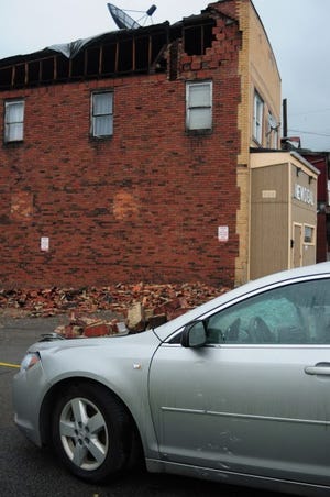 A portion of a wall collapsed Wednesday evening at a building on
Franklin Avenue in Ellwood City, which houses the New Deal tavern
and an apartment. No one was injured, but two vehicles were damaged
by falling bricks.