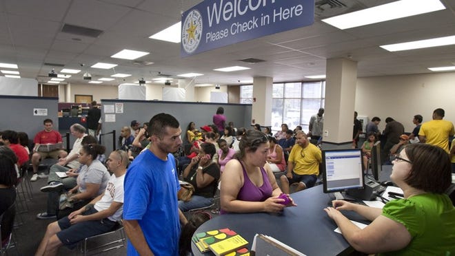Jose Valadez and sister Rosemarie Valadez talk Tuesday with driver's license examiner Megan Berryman at the check-in counter at the DPS office on North Lamar Boulevard. The megacenters' goal will be to do renewals in 30 minutes.