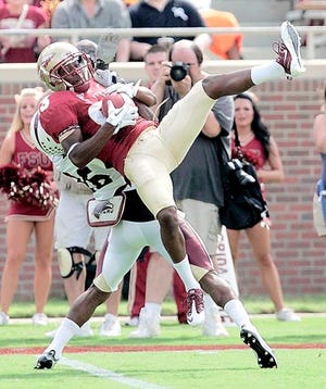 Florida State's Bert Reed makes a catch over the defense of Louisiana-Monroe's Cordero Smith in the second quarter of Saturday's game in Tallahassee. By STEVE CANNON, The Associated Press