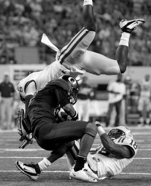 LSU safety Craig Loston (top) and Brandon Taylor (18) crash to
the ground as Oregon wide receiver Lavasier Tuinei makes a
reception in the first half of the Cowboys Classic on Saturday in
Arlington, Texas.
