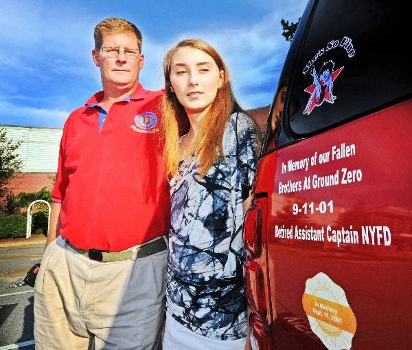 Lauren McElligatt, 16, and her father, former New York City volunteer firefighter Kevin McElligatt, stand next to their car, a mobile memorial to the event that reshaped both their lives.
