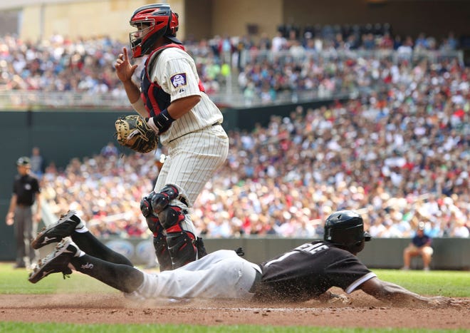 The Chicago White Sox's Juan Pierre scores on Alexei Ramirez's RBI double in front of Minnesota Twins catcher Rene Rivera during the first inning of the first baseball game of a doubleheader, Monday, Sept. 5, 2011, in Minneapolis.