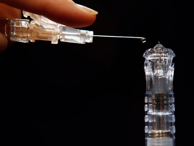 Flu shots have long been injected deep into muscle, requiring a needle an inch long or longer, such as the needle seen at left. However, a new version named: Sanofi Pasteur's Fluzone Intradermal, hitting the market this fall, at right, is less than a tenth of an inch long, the first flu vaccine that works by injecting just into the skin. The new needle is about as long as a single drop of fluid, as demonstrated in Washington, on Tuesday, Aug. 30. (AP Photo)