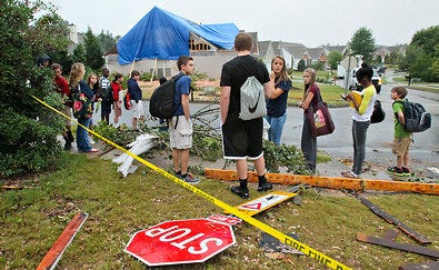 Students in Woodstock, Ga., waiting for a school bus Tuesday amid damage left by a tornado that struck the day before.