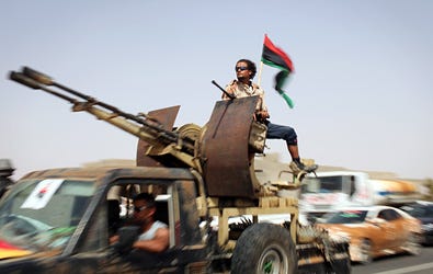 Rebel reinforcements from Tripoli drove through a checkpoint on their way to the front in Bani Walid, Libya, on Monday.