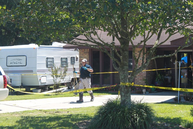 Arson Investigator Supervisor Lance LaMarca takes items from the backyard of the home.