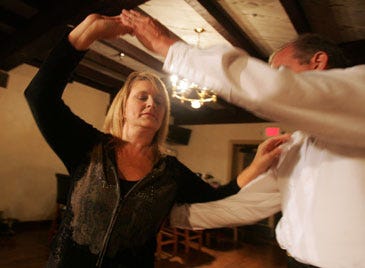 Photo by Daniel Freel/New Jersey Herald - Dance Instructor David Cross, right, demonstrates a step with contestant Colleen Apter, of Fredon, during a weekly “Dance with the Stars” dance lesson at the Lake Mohawk Golf Club in Sparta Tuesday.