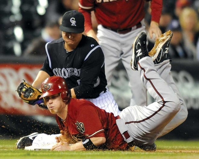 Rockies third baseman Jordan Pacheco applies the tag on the
Diamondbacks' Aaron Hill during the third inning of Wednesday's
game at Coors Field.