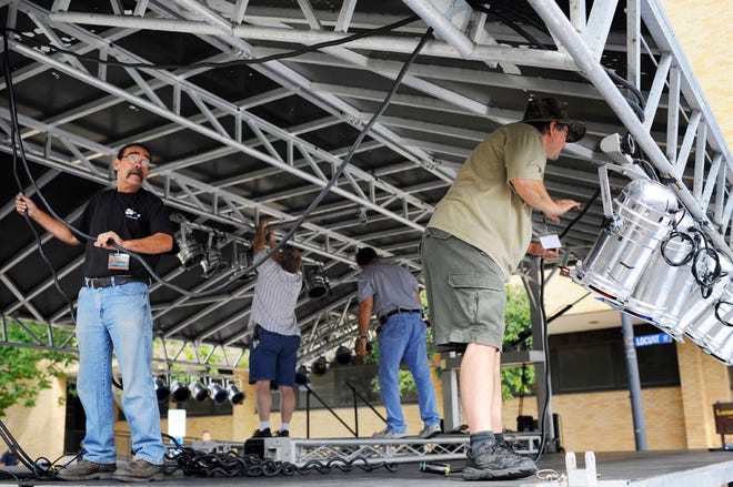 Workers set up lights Friday morning on the Mpix stage at Seventh and Locust streets for the Roots ’N Blues ’N BBQ Festival, which opens Friday in downtown Columbia.