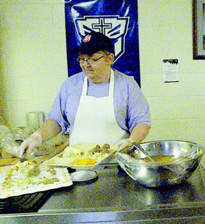 Volunteer Kathy Nichols helps serve food at the Salvation Army's community lunch on Wednesday, Sept. 7.