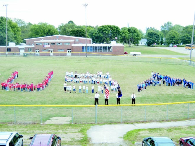 United West students spell out U.S.A. with the Alexis Color Guard standing by.