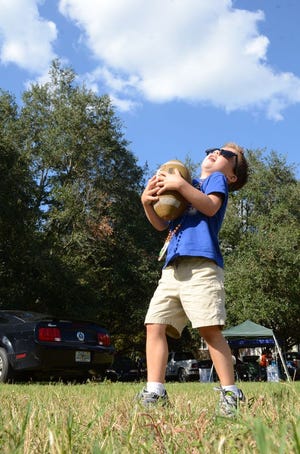 Hayden Cooper, 6, catches a football at Norman Field on Saturday in Gainesville.