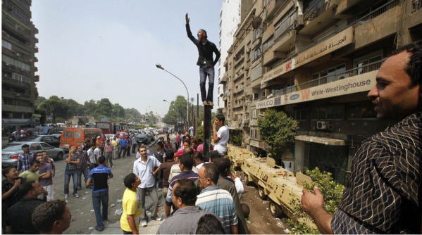 An Egyptian shouts slogans as he stands over the remains of a concrete wall around the Israeli Embassy a day after it was demolished by Egyptian activists in Cairo.