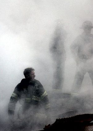 A firefighter emerges from the smoke and debris of the World Trade Center in New York on Sept. 14, 2001. A decade's worth of study has answered only a handful of questions about the hundreds of health conditions believed to be related to the tons of gray dust that fell on the city when the trade center collapsed, from post-traumatic stress disorder, asthma and respiratory illness to vitamin deficiencies, strange rashes and cancer. 
AP file photo/U.S. Navy, Photographer's Mate 2nd Class Jim Watson