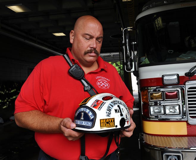 Framingham Fire Lt. Brad Smith holds the helmet he wore while working at Ground Zero in September, 2001. Lt. Smith was with the FEMA Urban Search and Rescue Mass. Task Force in New York City for one week, starting on the night of Sept. 11.