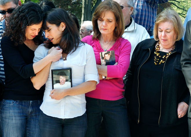 Family members of 9/11 victims, from left, sisters Danielle and Carie Lemack who lost their mother, Judy Larocque; Christy Coombs, who lost her husband Jeffrey; and Irene Ross who lost her brother, Richard Ross, on Flight 11, grieve during a moment of silence at the Garden of Remembrance in Boston, a memorial dedicated to the 206 Massachusetts victims of terrorist attacks.