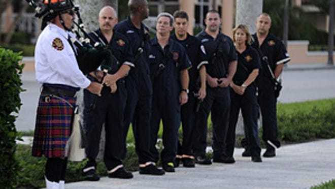 Palm Beach Fire-Rescue firefighter-paramedic Michael Dickson plays the bagpipes for his fellow firefighters as they gather for a memorial service to remember those lost on Sept. 11, 2001. The fire department held the service at sunrise on in front of the reflecting pond by Town Hall.