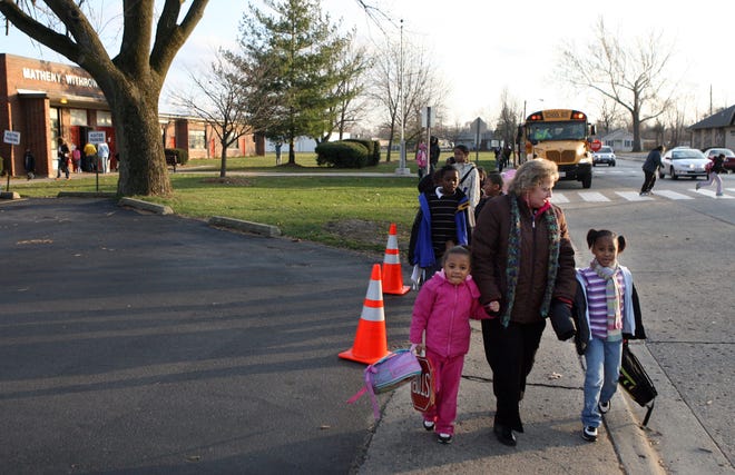 Matheny-Withrow Elementary principal Diane Motley walks students Ashiya Ogden, left, and Dariah Folds to a crosswalk that leads to Brandon Court where she lobbied to get students from to have more of a neighborhood school.