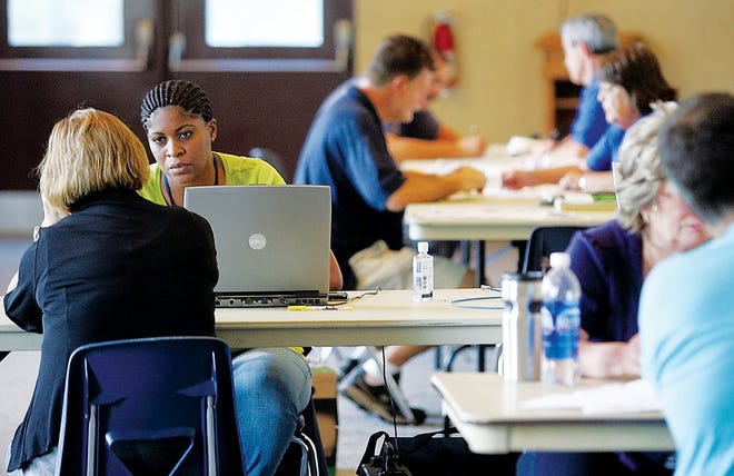 Photo by Daniel Freel/New Jersey Herald
 
Denise Dennis, an applicant service specialist with the Federal Emergency Management Agency, second from left, helps a client with her claim Tuesday at Sussex County Technical School's McNeice Auditorium in Sparta.