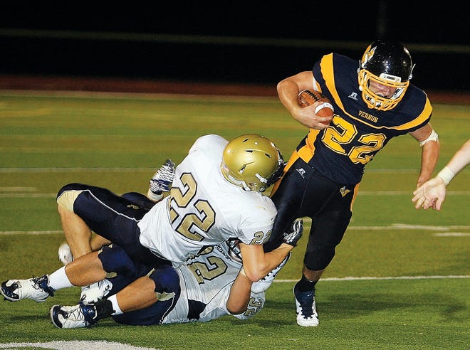 Photo by Randy Mills/Allproshots.com 
Vernon running back Tom Higginson, right, tries to escape the grasp of Roxbury’s Chris Colucci (22) and Anthony Salierno during Friday night’s opener. Vernon lost, 16-13.