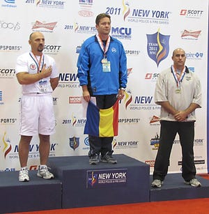 St. Joseph County Sheriff Sgt. Brian Stears (far right) stands on podium receiving his bronze medal in freestyle wrestling at the 2011 World Police and Fire Games.