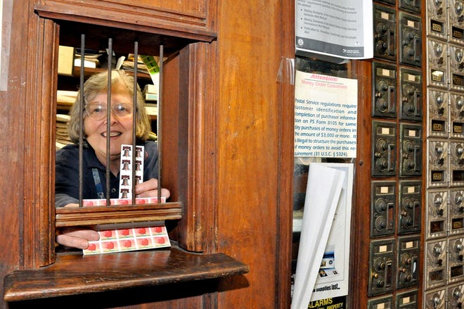 Postmaster Wilma Sue Wood shows a choice of stamps available at the post office window located inside the Wood & Swink store on April 7, 2009, in Evinston. With the United States Post Office facing a deficit projected to reach close to $10 billion this fiscal year, the government has announced plans to close 3,700 post offices. They include the location at the circa 1882 building, which was listed on the National Register of Historic Places in 1989.