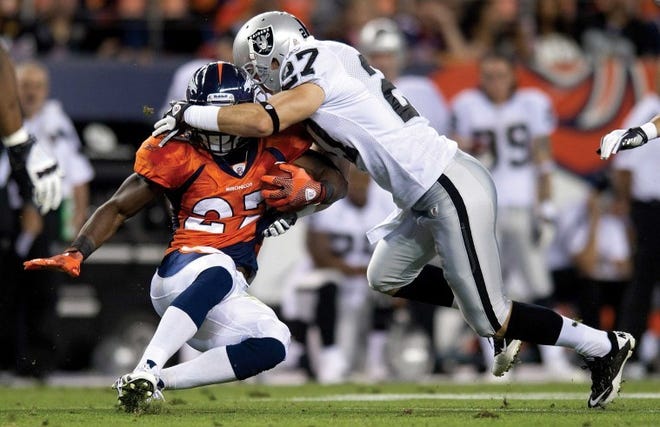 Denver Broncos running back Knowshon Moreno (left) is tackled by
Oakland safety Matt Giordano during the first quarter at Sports
Authority Field in Denver Monday.