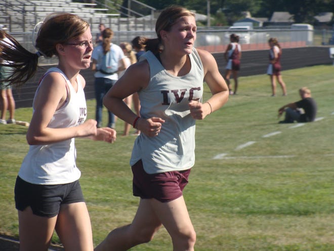 Chelsea McClain, left, and Aubrey Allison, right, run for the Illinois Valley Central cross country team in a recent home meet.