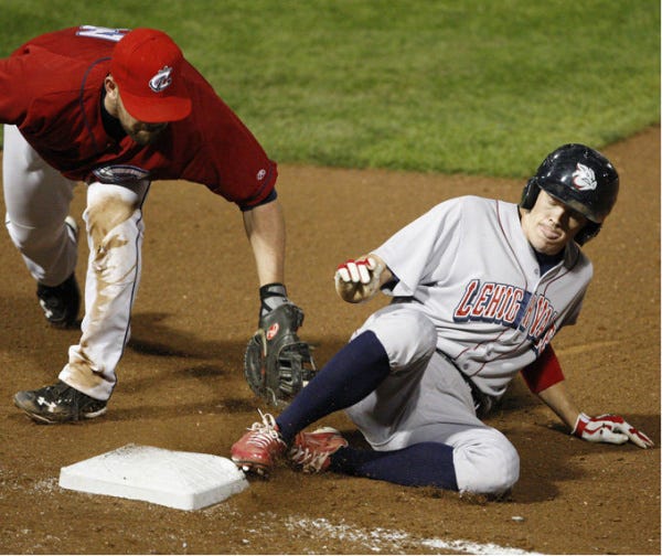 Clippers first baseman Beau Mills is late on a tag on a pickoff attempt of IronPigs base runner Rich Thompson.
