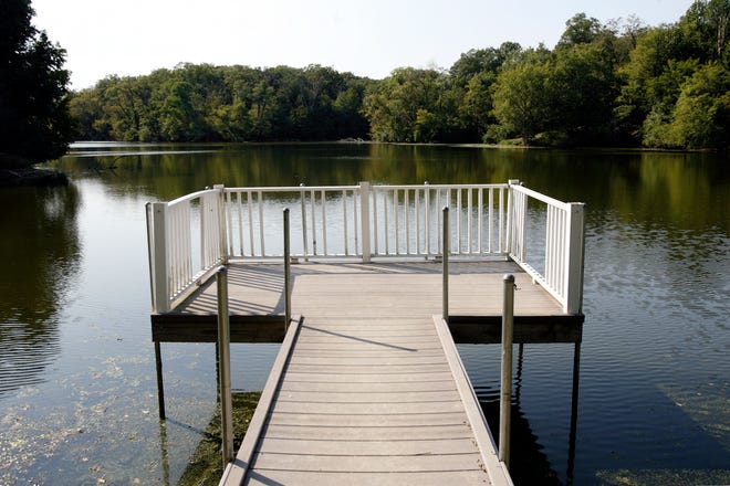 A deck extends over the water on property owned by the town of Virginia. The 18-acre lake, once used as the town’s water supply, is set to be auctioned off.