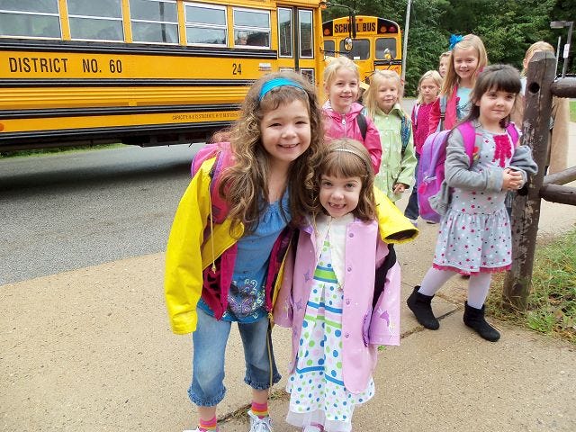 photo by Karen Gerrish
First-graders Alexis Savary and Sabrina Cavallaro stop for a quick picture after they get off the bus on the first day of school at the Hanson School last week.