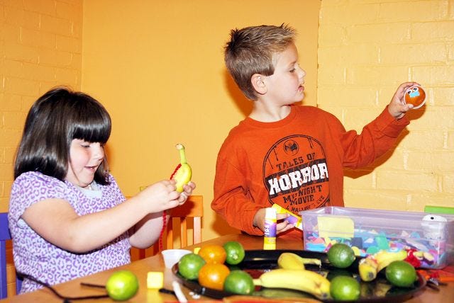 EJ Hersom/Staff photographer
Madison Poloquin, left, and Jacob Drew decorate fruit at the Children's Museum of New Hampshire in Dover Saturday.