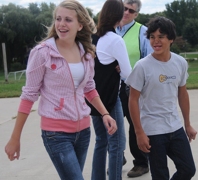 Adan Mejia walks with his friend, Courtney Gebben, left, Zeeland Christian School Thursday afternoon.