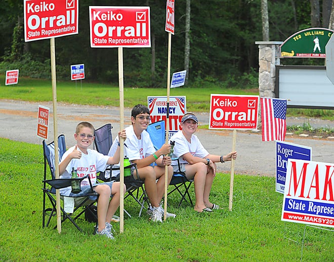 From left, Talbot Stearns, Ethan Orrall and Breaden Stearns hold signs at the entrance of the Lakeville polling place at the Lakeville Senior Center during the primaries of leading up to the special election to replace Rep. Stephen Canessa. The special election itself, between Republican Keiko Orrall and Democrat Roger Brunelle, will be held Tuesday, Sept. 20.