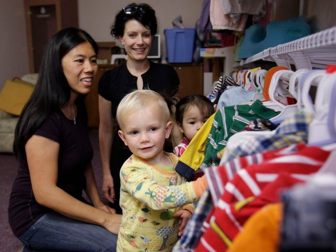 This June 30, 2011, photo shows Jude Chisan, 1, foreground, and his mother, Cen Campbell, center, as they look through clothes with Serena Weingrod, left, and her daughter, Adah, 2, at Blossom Birth in Palo Alto, Calif. (AP Photo/Paul Sakuma)