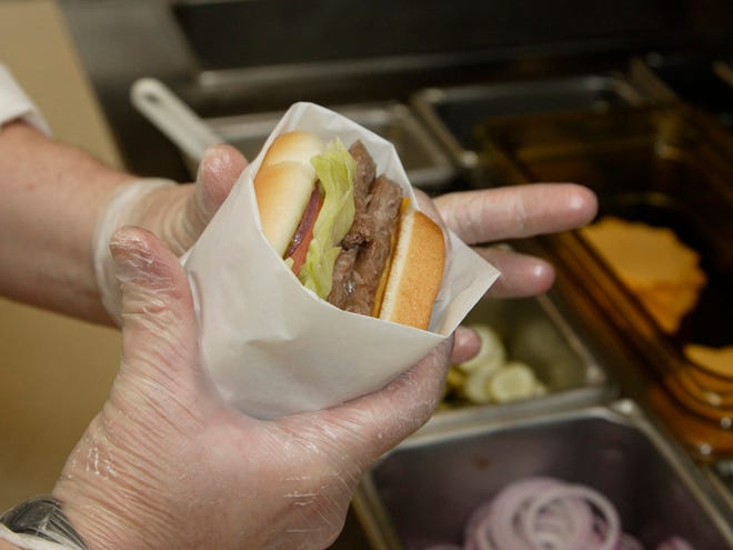 In this Sept. 15, 2011 photo, Liz Shires, Wendy's research and development laboratory coordinator, wraps a finished Dave's Hot 'N Juicy Cheeseburger in the lab at the company's international headquarters in Dublin, Ohio. (AP Photo/Paul Vernon)