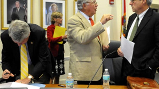 Town Council member Robert Wildrick, center, talks with council member Michael Pucillo, right, Wednesday after the Town Council passed a $58.5 million budget for fiscal year 2011-12. At left is council member Richard Kleid.