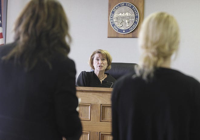 Family court Judge Rosemarie Hall speaks to a juvenile during a hearing as she stands with her public defender Amanda James.