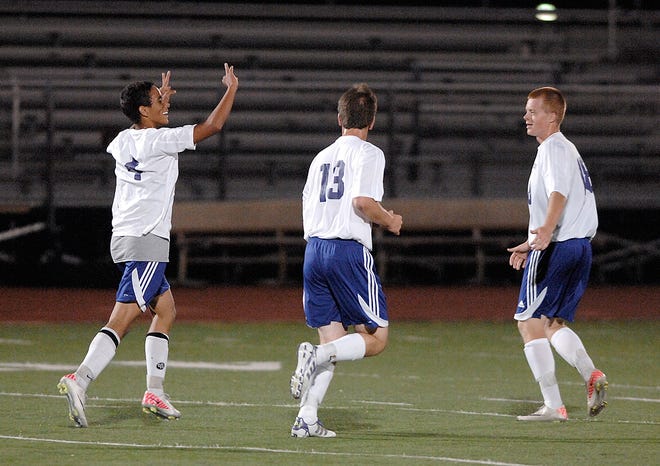 Hickman's Peter Plakours, left, celebrates his second goal in the first half with fellow players Nathan Wikle, center, and Brad Storm.
